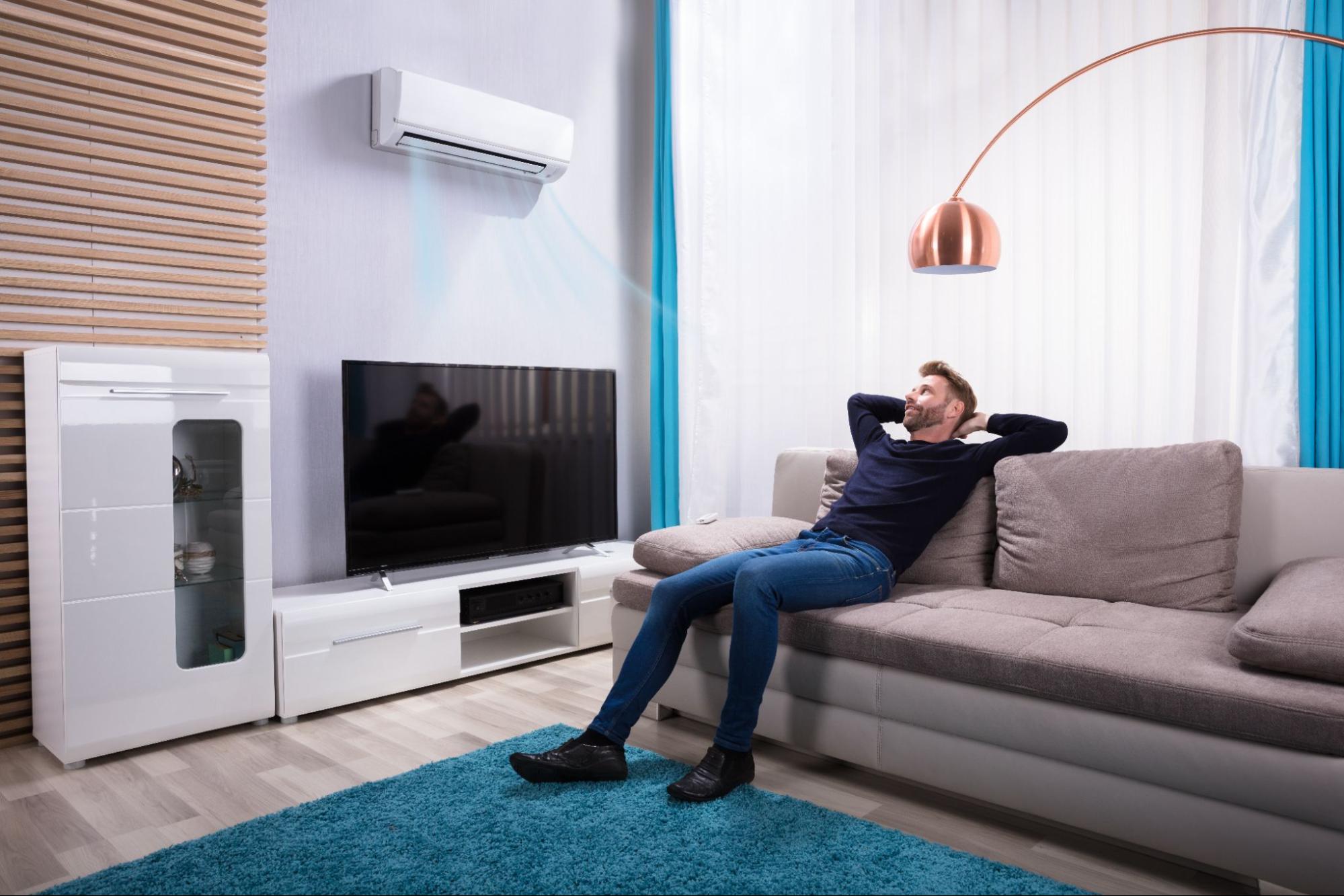 Man sitting on couch near air conditioner