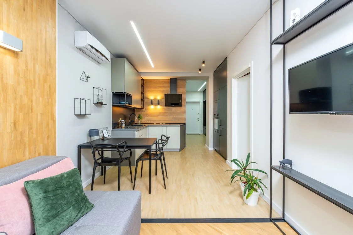 A contemporary apartment set up with a kitchen and table and chairs 